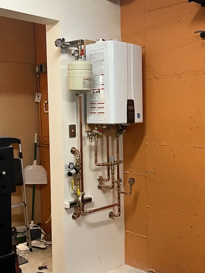 Plumbing technician inspecting water heater connections in Port Wentworth